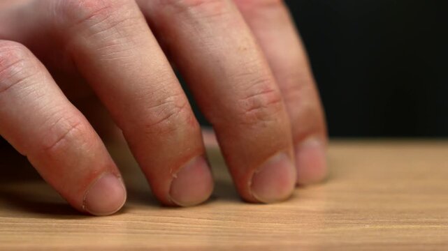 Fingers of a worried man tapping on a table in an office.
Hands of a worried man.
Nerves and stress.
Expectation and gesture of nerves.
Finger tapping on a surface from nerves