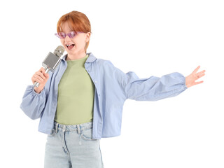Teenage redhead girl in sunglasses with microphone singing karaoke on white background
