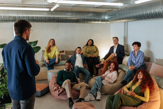 Creative director leading a brainstorming meeting with his team in a modern office