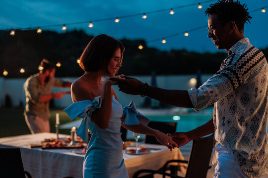 Couple dancing at a night party near the pool - Powered by Adobe