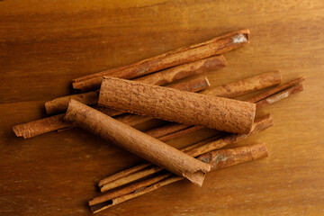 Cinnamon sticks dried tree bark spice on rustic wooden table background.