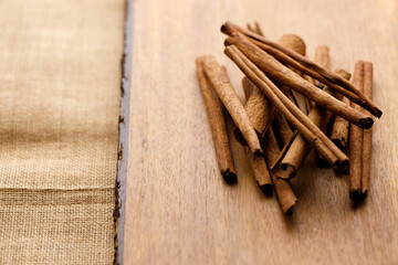 Cinnamon sticks dried tree bark spice on rustic wooden table background.
