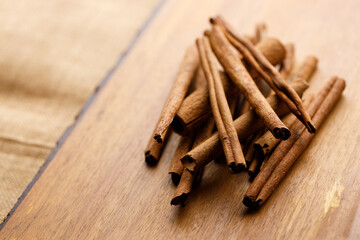 Cinnamon sticks dried tree bark spice on rustic wooden table background.