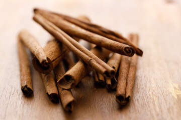 Cinnamon sticks dried tree bark spice on rustic wooden table background.