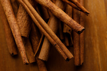 Cinnamon sticks dried tree bark spice on rustic wooden table background.