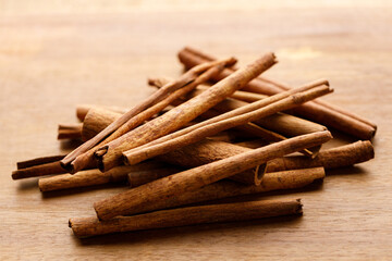 Cinnamon sticks dried tree bark spice on rustic wooden table background.