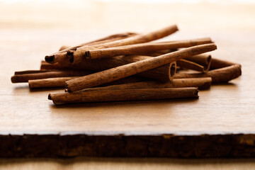 Cinnamon sticks dried tree bark spice on rustic wooden table background.