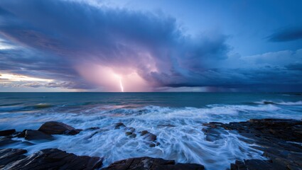 Dramatic lightning strike illuminates stormy ocean sky over rugged coastline