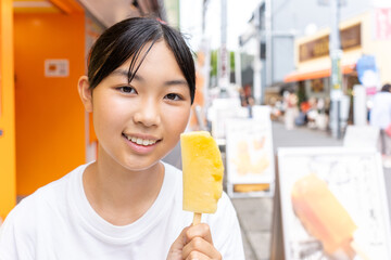 鎌倉観光をしながら食べ歩きをする10代の女性