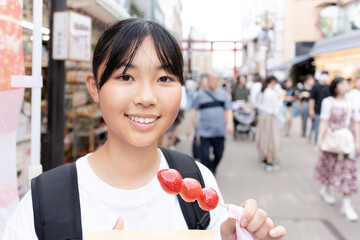 鎌倉観光をしながら食べ歩きをする10代の女性