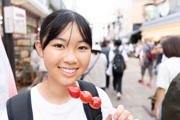鎌倉観光をしながら食べ歩きをする10代の女性