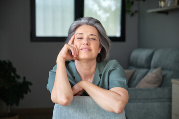 Confident smiling woman at home feeling satisfied and secure