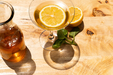 Overhead shot of a warm lemon tea in a cup, neatly served on a wooden table, highlighting freshness...