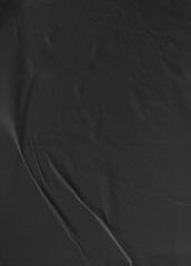 Black crumpled and creased glued paper isolated on a clean background. The textured surface adds depth and character, ideal for modern and artistic design projects. Hoja papel negro mojado.