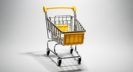 Miniature silver metal shopping cart with vibrant yellow handle and accents on white background