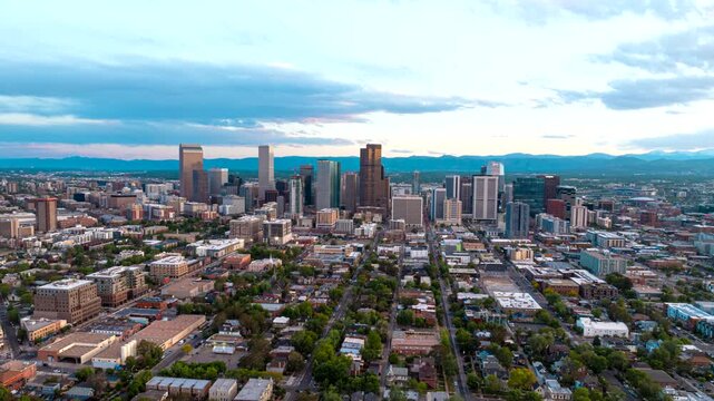 Arcing aerial hyperlapse view of Denver Mile High city skyline over Curtis Park