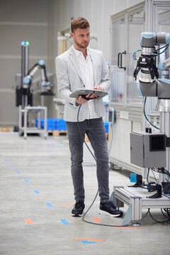 Engineer operating modern machine through controller in industry