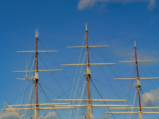 Tall ship masts and rigging against a clear blue sky, maritime detail capturing nautical heritage and sailing tradition