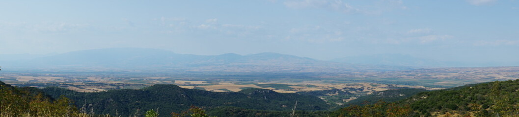 Fototapeta premium a high angle panorama of a vast greek valley with fields and mountains, concept of business travel, agriculture, tourism.