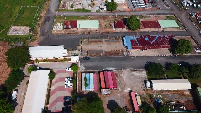 Top down aerial of industrial company yard in Abuja with colorful roofs and cars