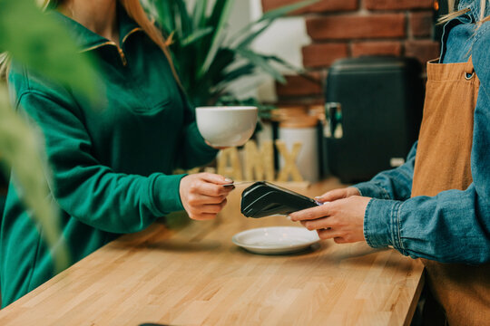 Customer doing contactless payment via credit card at cafe