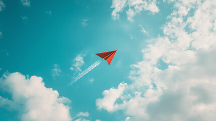 Red Paper Airplane Flying in Blue Sky with Clouds and Copy Space