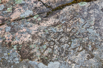 Close-up of weathered stone with carved historic dates and symbols. Deep grooves, rough texture, and aged patina, history, memory, and timeless northern heritage
