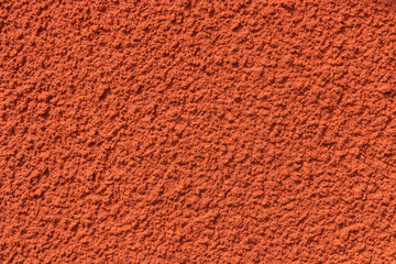 Plastered red wall with rough texture, uneven surface highlight rustic Nordic craftsmanship and natural, tactile quality