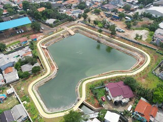 A beautiful lake with ornamental plants growing on the edge is located in the middle of the city