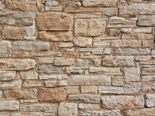 Fototapeta premium Neutral Stone Facade Architectural Detail with Rough Texture and Varying Shades.