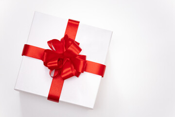 top view of a festive  gift box  tied with a red satin ribbon with a bow isolated on white background