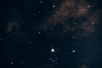 A mesmerizing view of the night sky filled with countless bright stars scattered across the dark expanse. Wispy clouds or nebulae add texture to the cosmic scene.
