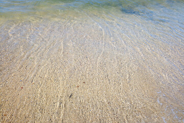 A Clear Water Surface on a Golden Sand Beach. Concept Purity and tranquility.