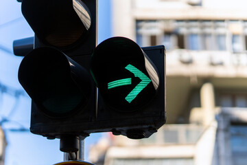 Green arrow illuminated on a traffic light, symbolizing permission, progress, and moving forward in...