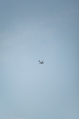 A small airplane in a pale blue sky with a few wispy clouds. The clean, minimalist composition...