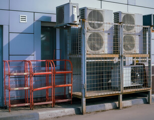 Air compressor or air condenser located on support outside building
