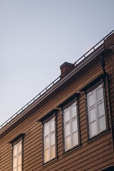  A close-up of a traditional wooden building in Tromsø, featuring classic windows and a chimney against a soft sky, capturing the charm of Scandinavian architecture.