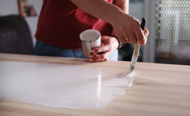 Woman Painting Wooden Surface With Paint Table Using A Brush