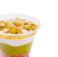 Delicious layered dessert with fruits, yogurt, and nuts in a clear cup