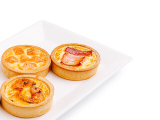 Mini savory tarts with assorted fillings showcased on a white plate