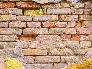 Old Brick Wall with Peeling Plaster and Paint Layers