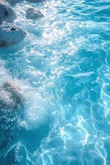 Rippling blue water with sparkling light reflections and natural rock formation
