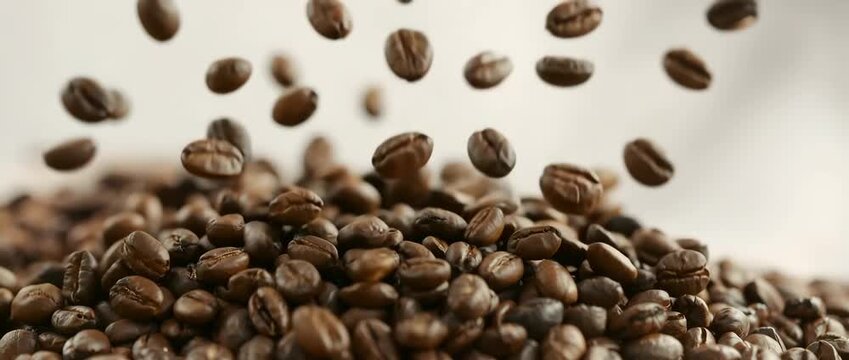 Close up of fresh roasted coffee beans falling, 4K Video