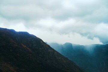 Fog rolling over a mountain range on a cloudy day