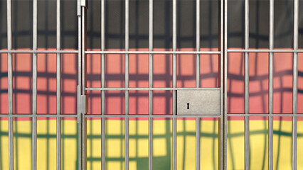 Gefängnisgitter mit Deutschlandfahne im Hintergrund