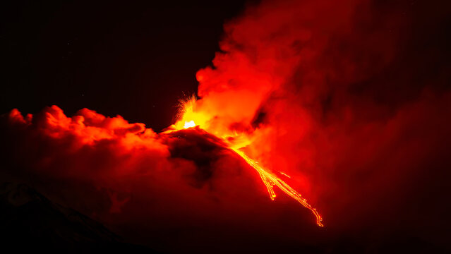 eruption of volcano during night ,  Night sky fire explosion burst flame smoke burning light glow hot. Erupting volcano Etna in Sicily, Italy.