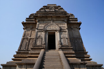 Obraz premium Ancient Indian Temple Entrance: Intricate Stone Carvings, Majestic Architecture, Sunny Day