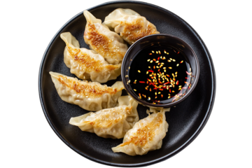 Plate of chicken dumplings with soy sauce, isolated on white background.