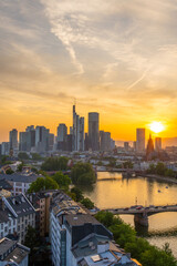 Naklejka premium Frankfurt City Downtown, Residential Buildings, Bridges and Main River at Sunset. Wide Shot. Aerial View. Golden Hour. Hesse, Germany