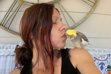 person and parrot kissing